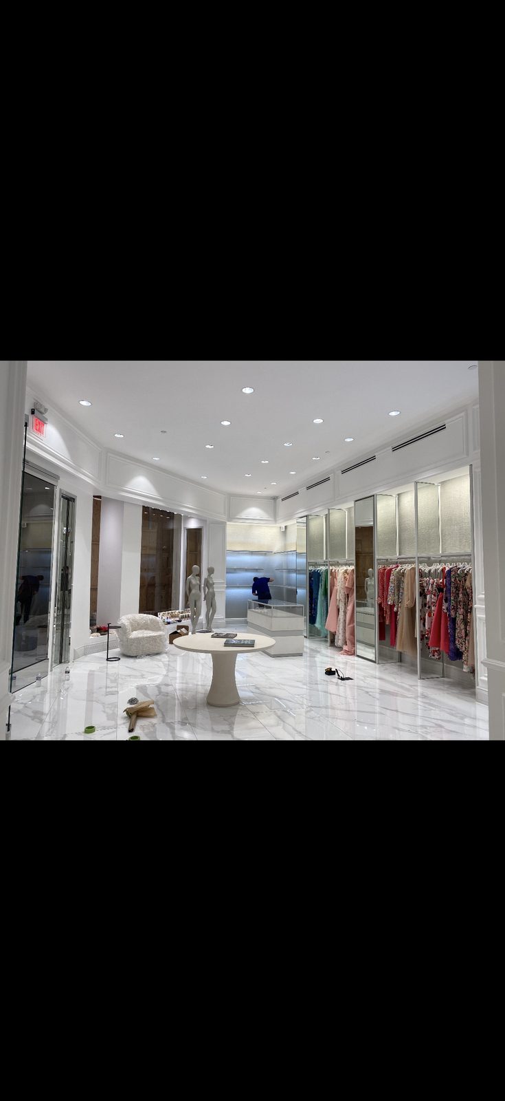 Commercial boutique interior with white walls, molding, and marble floors