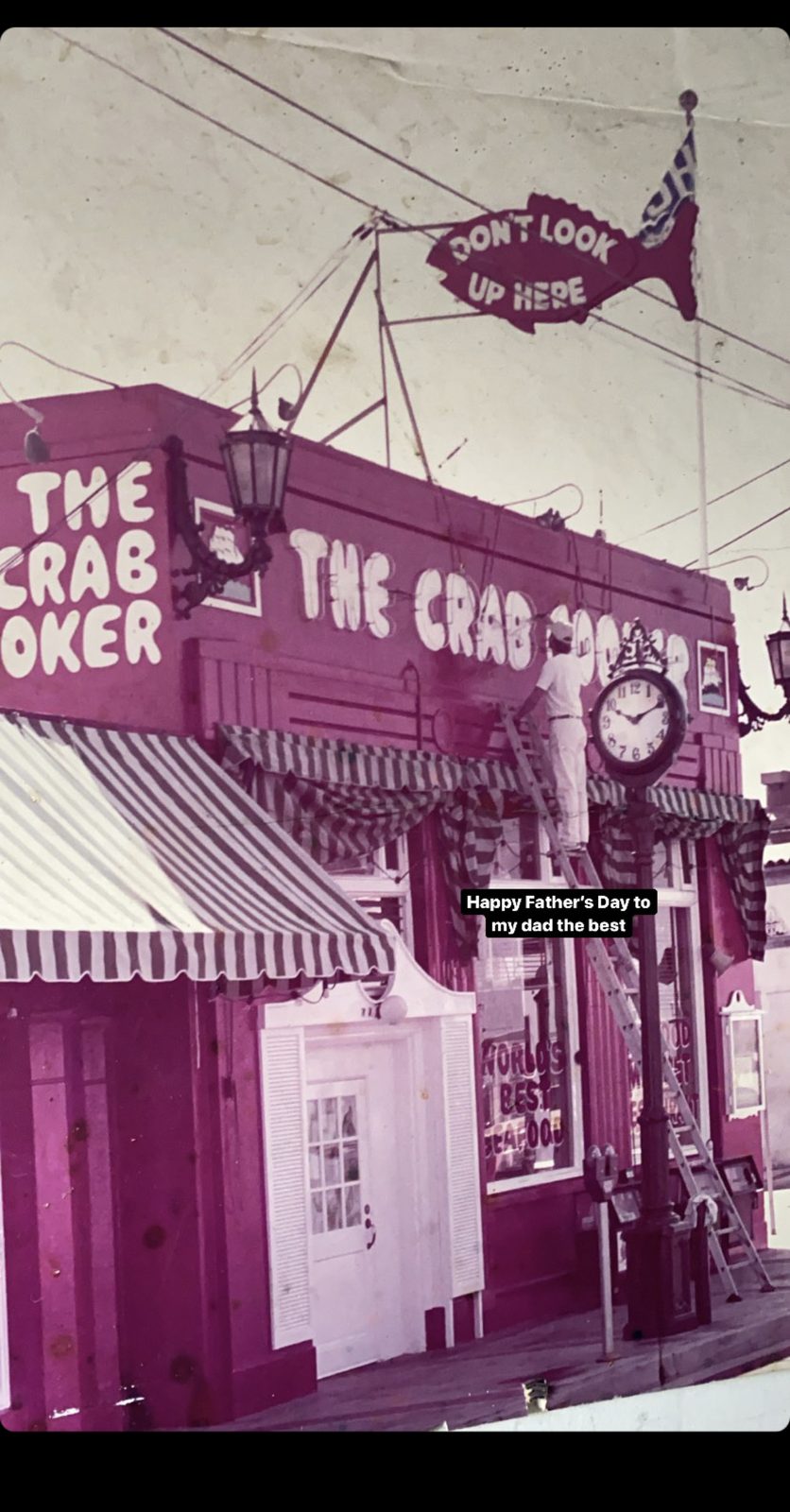 Historic photo of painter on ladder at The Crab Cooker restaurant exterior