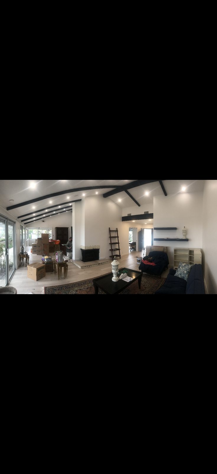 Open living room with white walls and dark beams