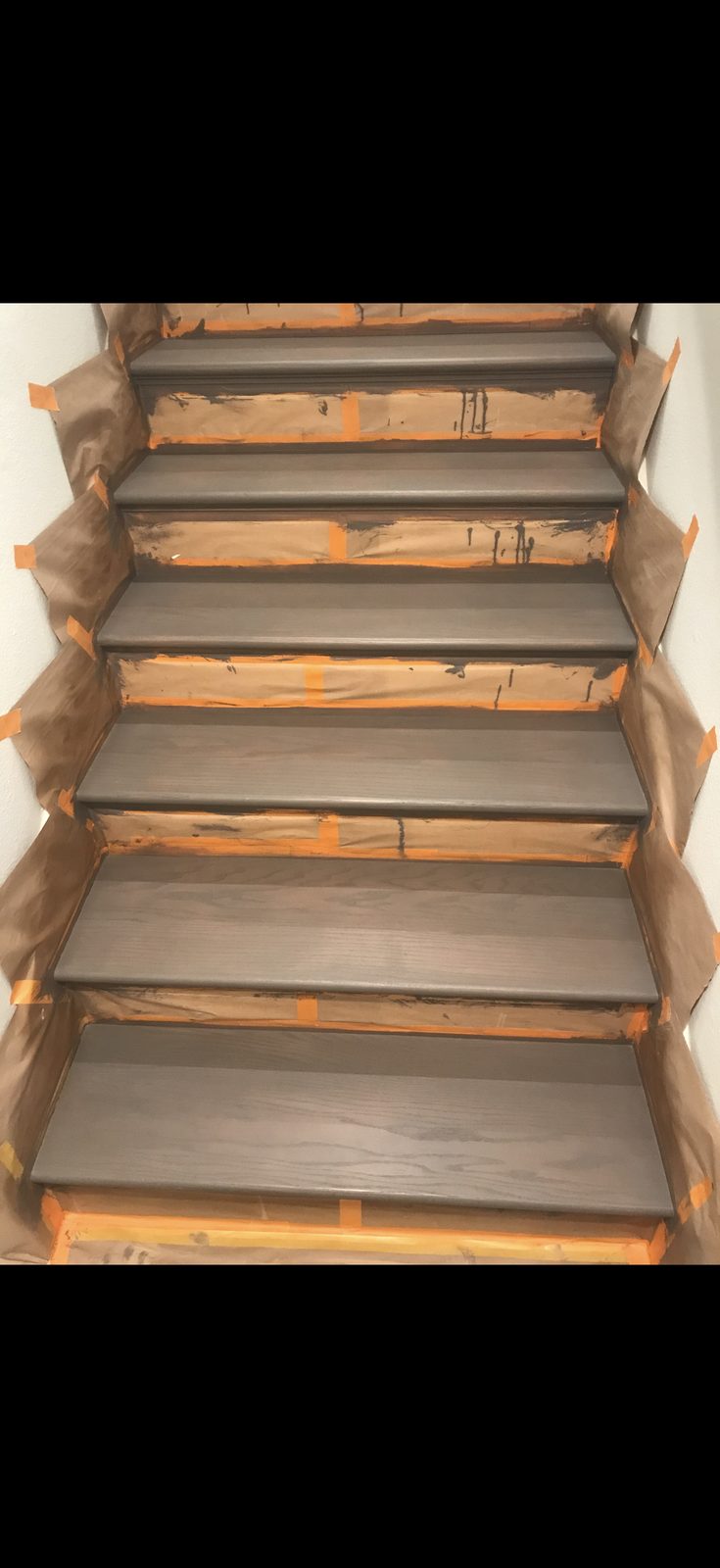 Stairs in progress with masking and dark tread stain